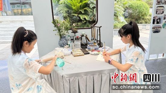郭鑫愉(右)正在进行花鸟画创作。刘倩 摄 郭鑫愉(右)正在进行花鸟画创作。刘倩 摄