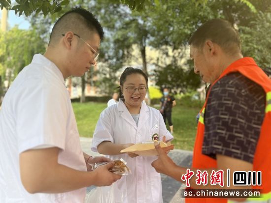 医务人员为环卫工人送上清暑饮品。 西充县中医医院供图 医务人员为环卫工人送上清暑饮品。 西充县中医医院供图
