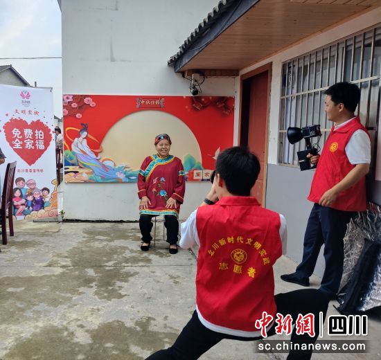 志愿者免费为村民拍照。 北川县委宣传部供图 志愿者免费为村民拍照。 北川县委宣传部供图