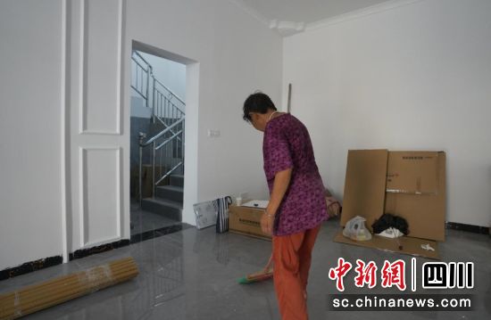 肖天芬正在清洁新居。刘倩 摄 肖天芬正在清洁新居。刘倩 摄