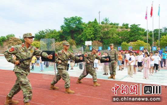 在西充县凤鸣镇小学操场,民兵应急排为师生们展示队列训练和警棍盾牌操。衡欢 摄 在西充县凤鸣镇小学操场,民兵应急排为师生们展示队列训练和警棍盾牌操。衡欢 摄