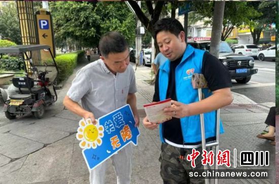 志愿者向居民介绍《无障碍环境建设法》。四川美望儿童关爱公益慈善基金会 供图 志愿者向居民介绍《无障碍环境建设法》。四川美望儿童关爱公益慈善基金会 供图