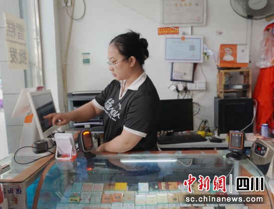 零售户熊雪梅使用收银机查看销售数据。余婉霜 摄 零售户熊雪梅使用收银机查看销售数据。余婉霜 摄