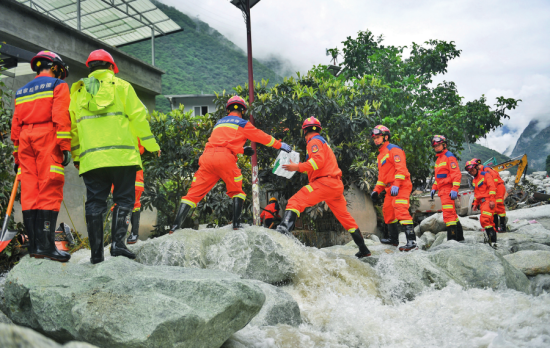 在四川省康定市日地村,救援人员涉着山洪传送物资(2024年8月5日摄)刘坤摄/本刊 在四川省康定市日地村,救援人员涉着山洪传送物资(2024年8月5日摄)刘坤摄/本刊
