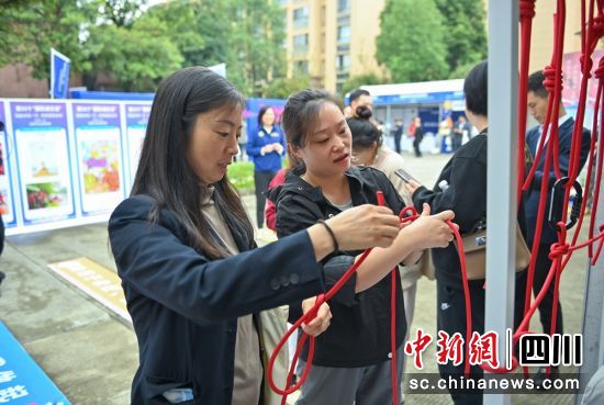 活动现场群众学习如何打绳结。记者 刘忠俊 摄 活动现场群众学习如何打绳结。记者 刘忠俊 摄