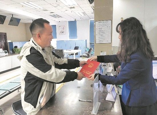 市民接过成都市颁发的首本林地经营权不动产权证书。 市民接过成都市颁发的首本林地经营权不动产权证书。