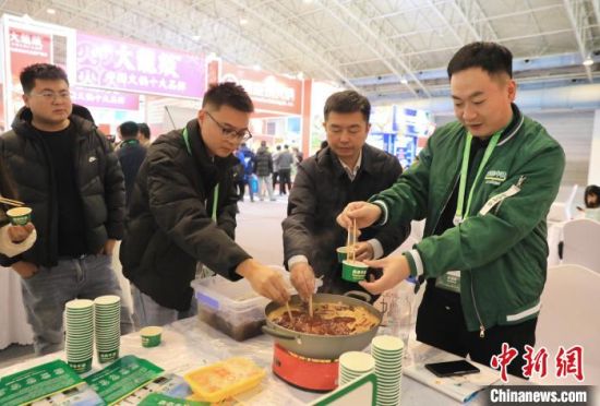 11月26日,第二届中国国际供应链促进博览会在北京开幕,图为展商和观众在川渝火锅产业供应链展区品尝四川火锅。 中新社记者 王磊 摄 11月26日,第二届中国国际供应链促进博览会在北京开幕,图为展商和观众在川渝火锅产业供应链展区品尝四川火锅。 中新社记者 王磊 摄