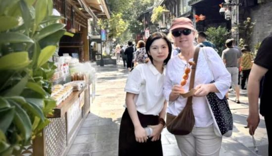 工行志愿者陈美君正在为外籍游客介绍成都热门景点 工行志愿者陈美君正在为外籍游客介绍成都热门景点